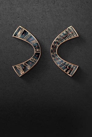 此图片展示了两个弯曲的金色腕表组件，可能是日历指示器。左侧部件显示了星期几的缩写（MO-SU），而右侧部件显示了日期（1-31），两者都置于虹彩镶嵌物上。